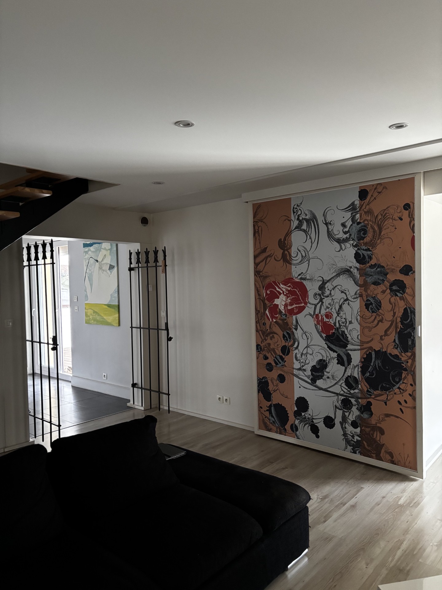 Pièce rénovée avec plafond tendu blanc, murs peints en blanc et porte coulissante imprimée
